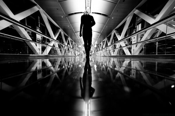 Black and white photo of a girl walking through the airport