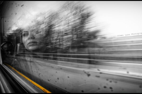 A blurry, black-and-white picture of the street and the light on the glass