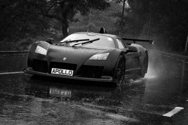 Auto sportiva che vola su una strada bagnata sotto la pioggia