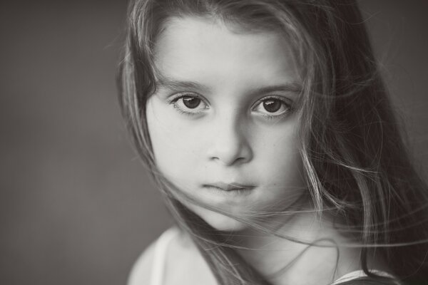 The girl looks into the frame on a black and white background