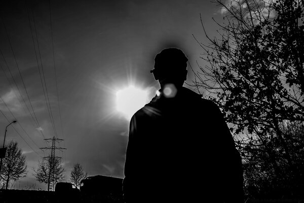 Sagoma in bianco e nero di un uomo su uno sfondo al tramonto