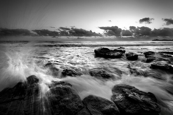 Storm and foam of waves breaks on boulders