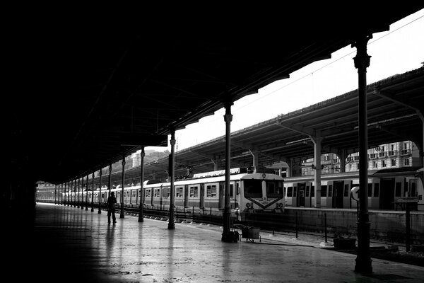 Ein schwarz-weißer Bahnhof, ein einsamer Mann auf Peron