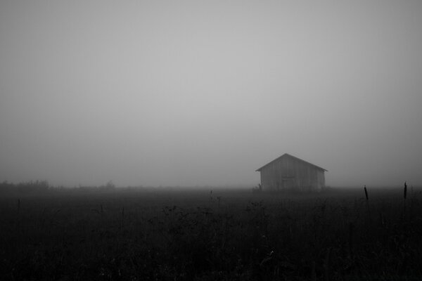 Paisaje de granero en blanco y negro en la niebla