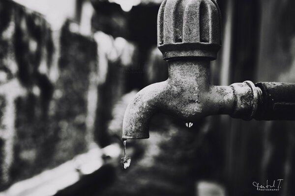 A drop of water from a metal faucet