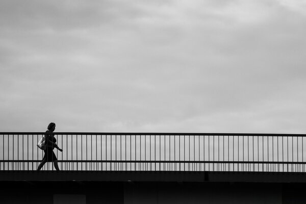 Puente blanco y negro y silueta de mujer