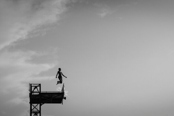 Salto de la torre contra el cielo en blanco y negro