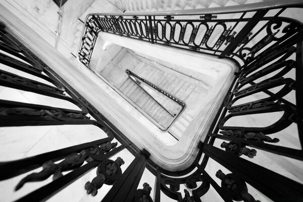 Black and white staircase with wrought iron railings