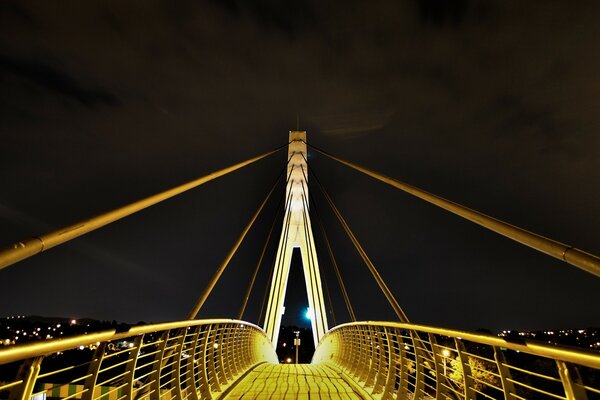 Die von Laternen beleuchtete Brücke und die Stadt ist sichtbar