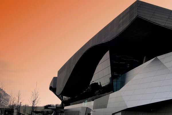 A massive architectural statue against the backdrop of a beautiful sunset