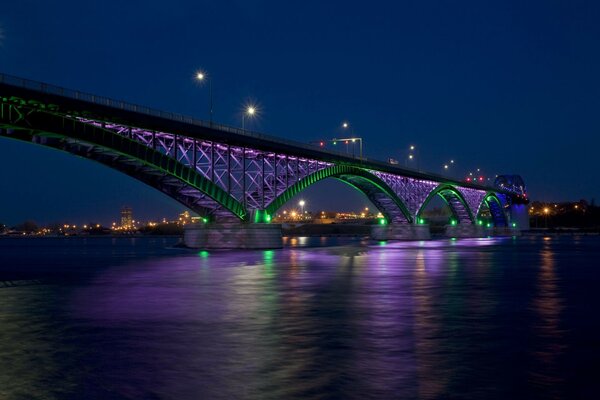 Puentes iluminados y superficie de agua en la noche