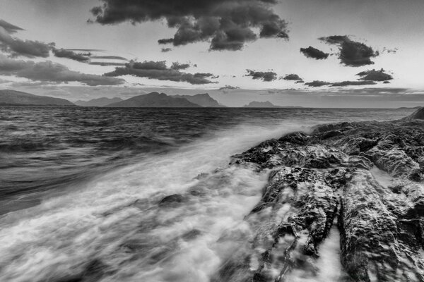 Waves crash against sharp rocks