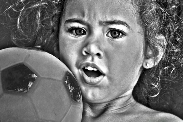 Чорно-біла фотографія дитини з м ячем