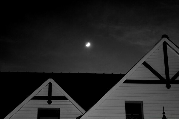 Monochrome photo of the Moon on the background of the house