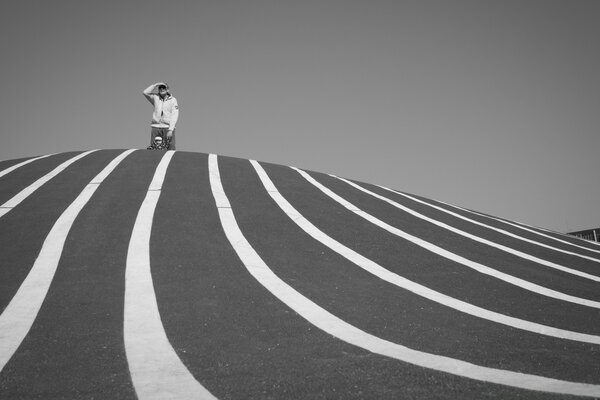 Foto in bianco e nero di un uomo in Dalek su una collina