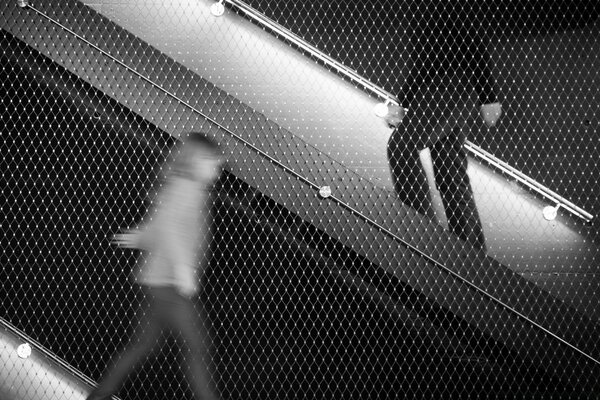 People on the escalator in black and white