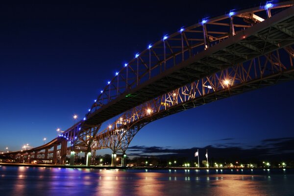 Puente iluminado sobre el río al anochecer