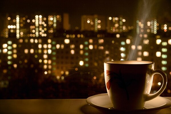 Tasse und Untertasse vor dem Hintergrund der Stadtlichter