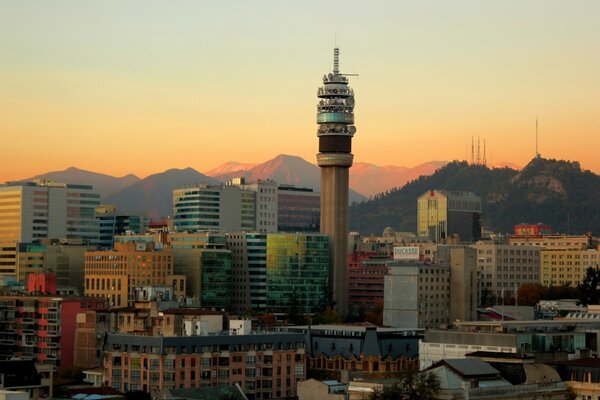 Stadt mit Turm im Zentrum und Bergen im Hintergrund