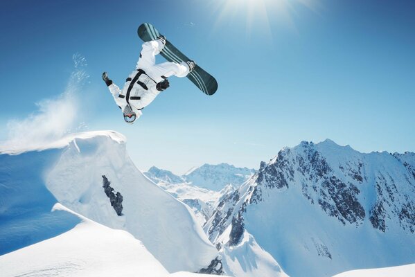 The trick of a snowboarder in the snowy mountains