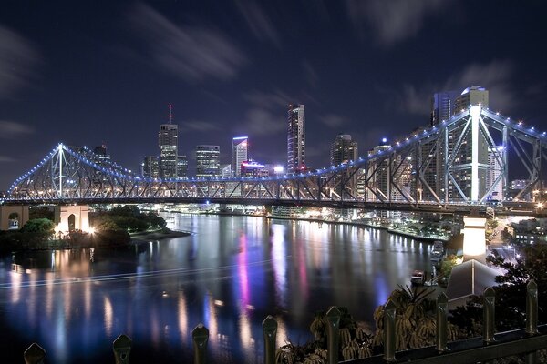 Suspension bridge across the river on the background of skyscrapers