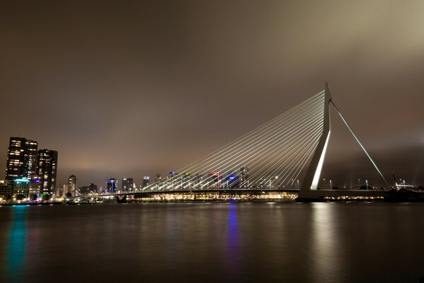 Foto nocturna de la bahía con el puente y la ciudad nocturna en luces