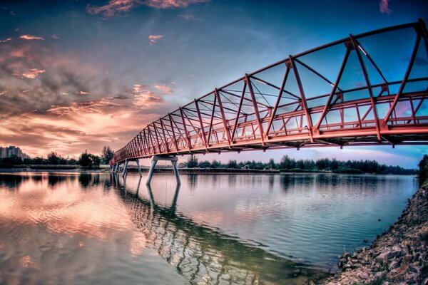 Brücke über dem Fluss im Hintergrund des Sonnenuntergangs