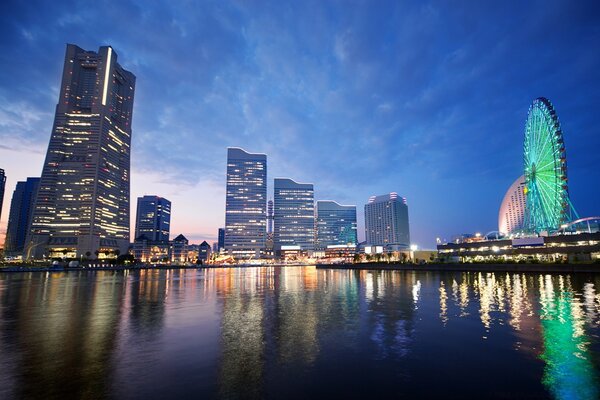 Reflections of the Ferris wheel in the surface of the megapolis river