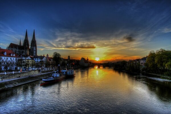 Fluss vor dem Hintergrund der aufgehenden Sonne und der antiken Stadt