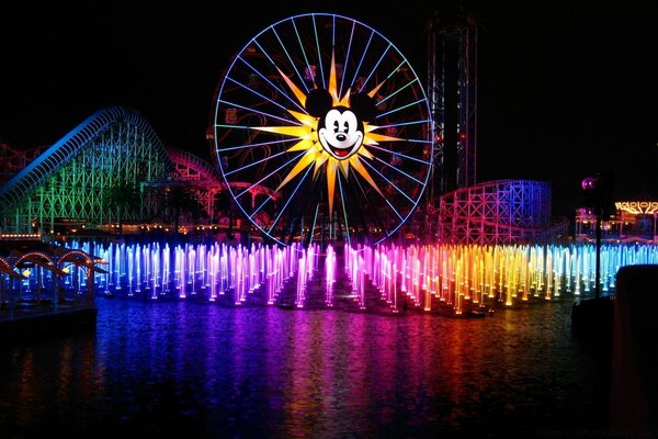 Grande roue avec une image de Mickey Mouse sur fond de fontaines