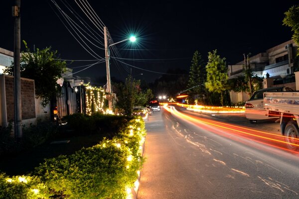 Rua noturna com marcas de faróis de carro