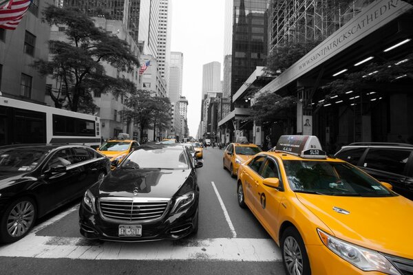 Coches y taxis en la calle con rascacielos