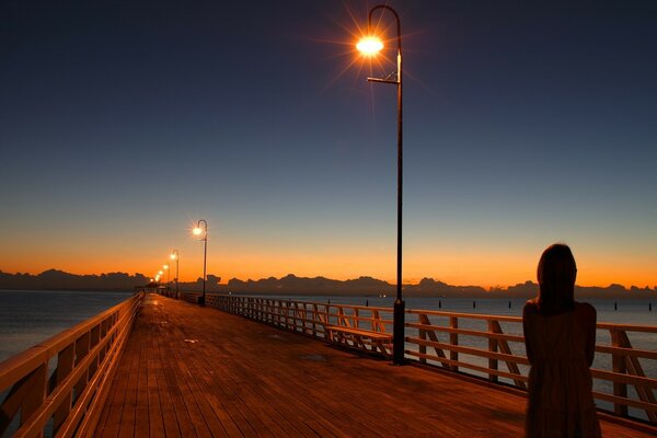 Figura solitária na ponte sobre o rio