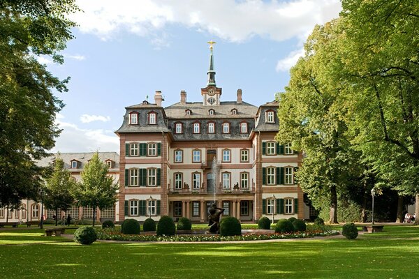 An ancient building on a background of green lawns and trees