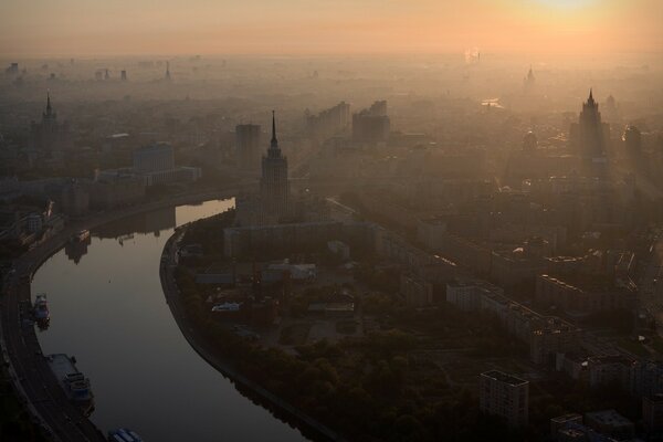 Brumoso amanecer sobre el río de la ciudad