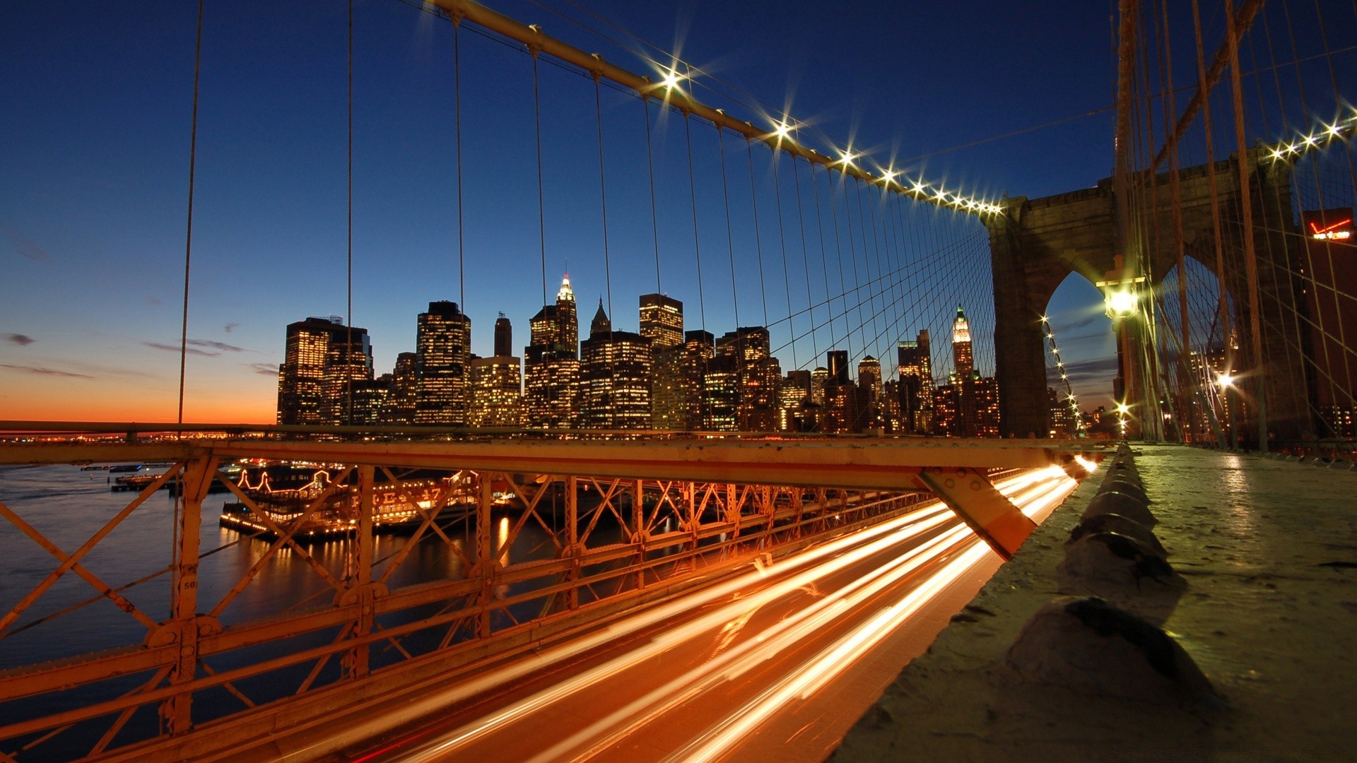 other city bridge travel architecture city transportation system dusk building evening water sky light urban sunset downtown river road modern