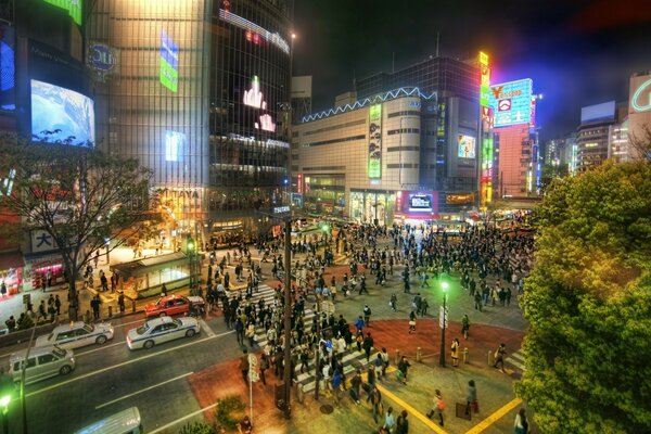 Ciudad nocturna en un cruce de peatones concurrido