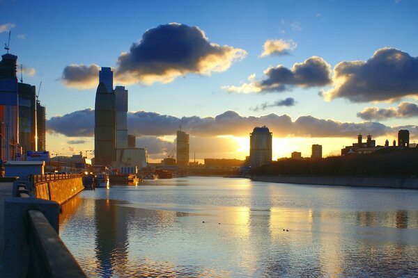 Amanecer junto al agua en una gran ciudad