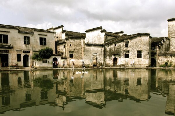 Un edificio di colore grigio riflesso nell acqua