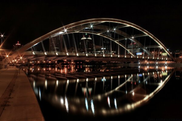 El puente nocturno se refleja en el agua