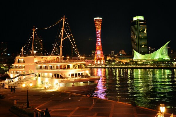 Ciudad nocturna y barco en el muelle