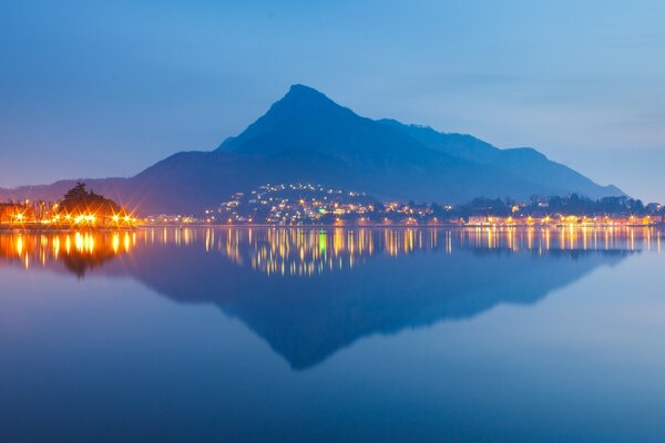 Die Reflexion des Berges und der Lichter der Stadt im Wasser