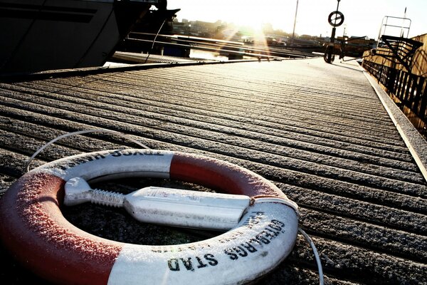 The lifebuoy is lying on the pier