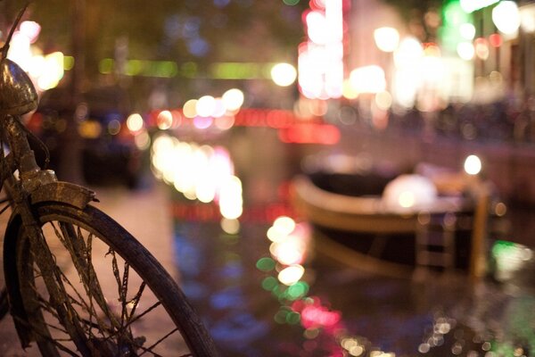 A bicicleta está no cais. Cidade noturna