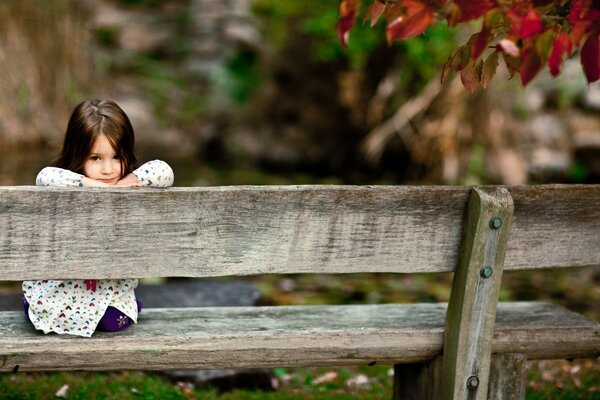 A little girl on an old bench