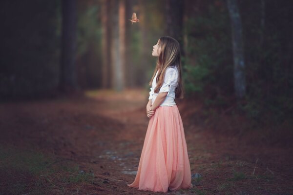 A child in a beautiful dress in the forest