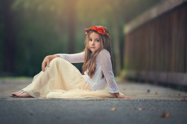 Fille dans une Couronne assise sur l asphalte