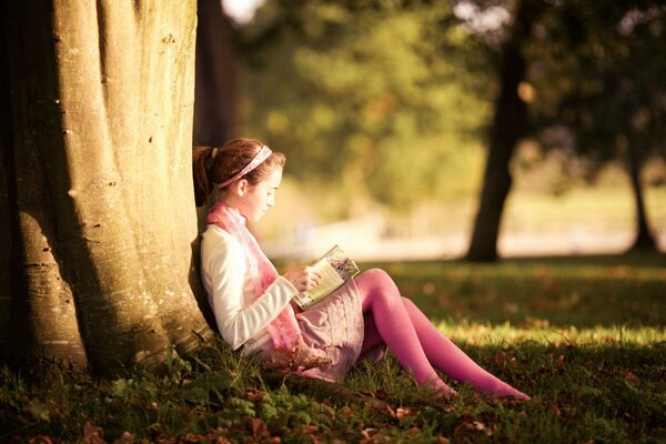 Alice lit un livre sous un arbre