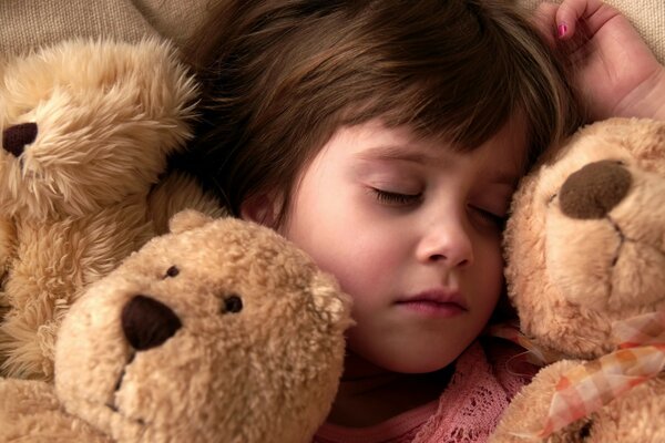 A child sleeps among soft toys