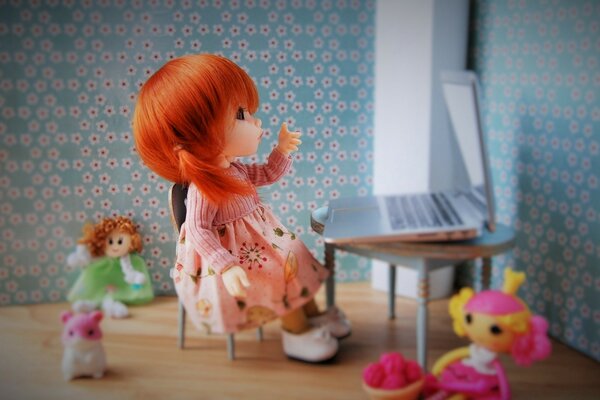 A doll with a laptop among the toys